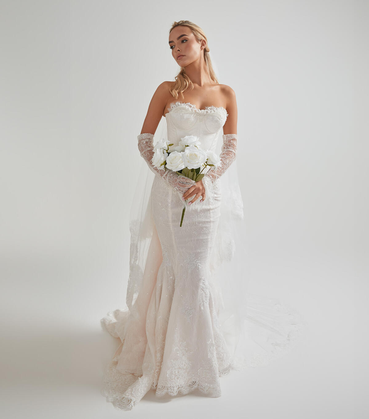 Completed bridal gown with bouquet at AM Bridal Studio Bride wearing her fully tailored wedding gown and holding her bouquet at AM Bridal Studio.