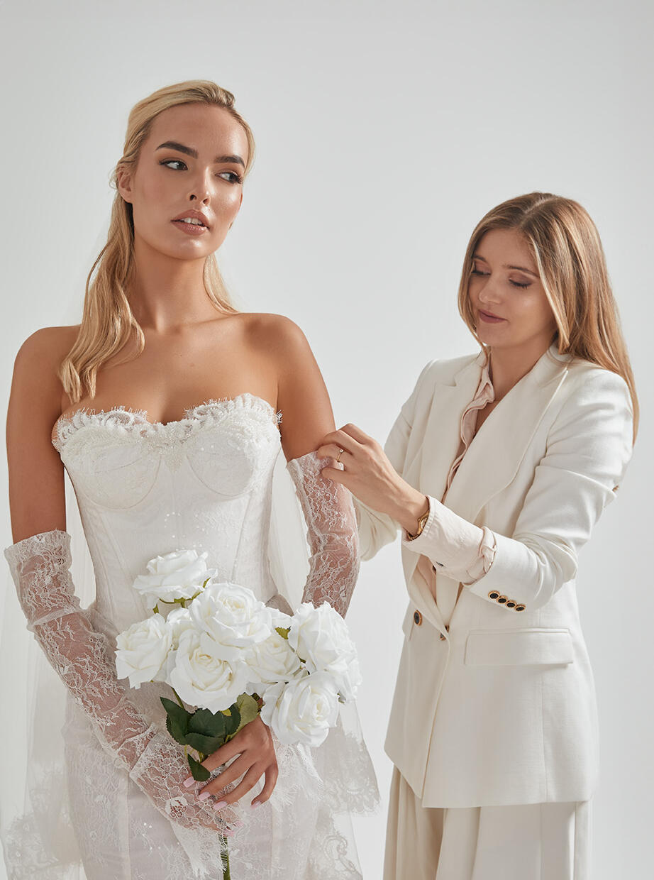 Final wedding gown adjustments at AM Bridal Studio AM Bridal Studio specialist making final adjustments to a bride’s wedding gown during her fitting.